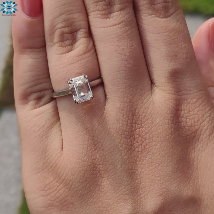 Double prong cathedral setting ring with emerald cut stone.
