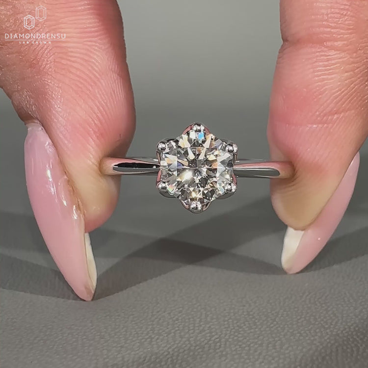 Round cut diamond ring featuring a tapered shank and hidden accents.
