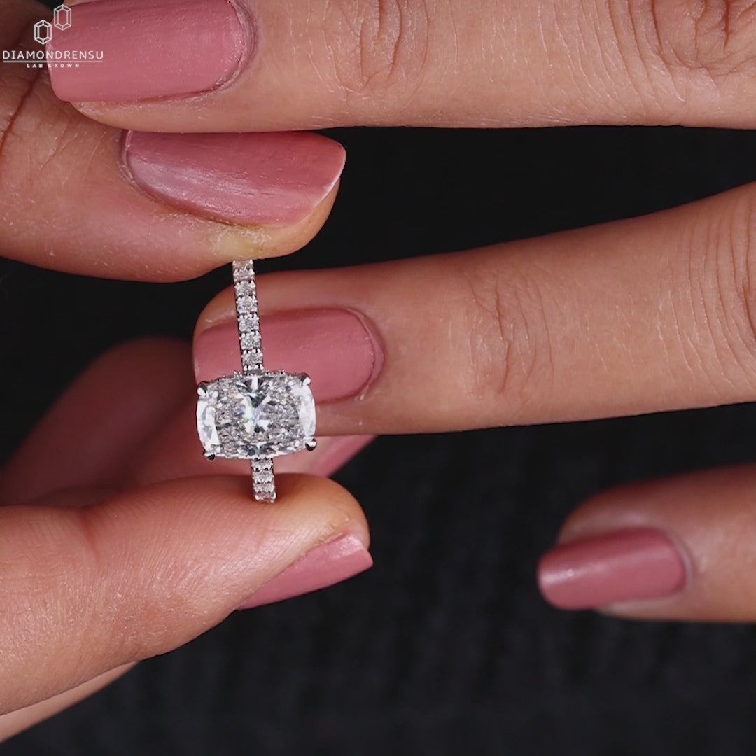 UK engagement ring designed with a cushion cut diamond and claw prong ring style.