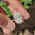Oval moissanite engagement ring featuring hidden halo and round cut pave setting.
