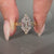 Art deco style marquise diamond ring with tapered shank.