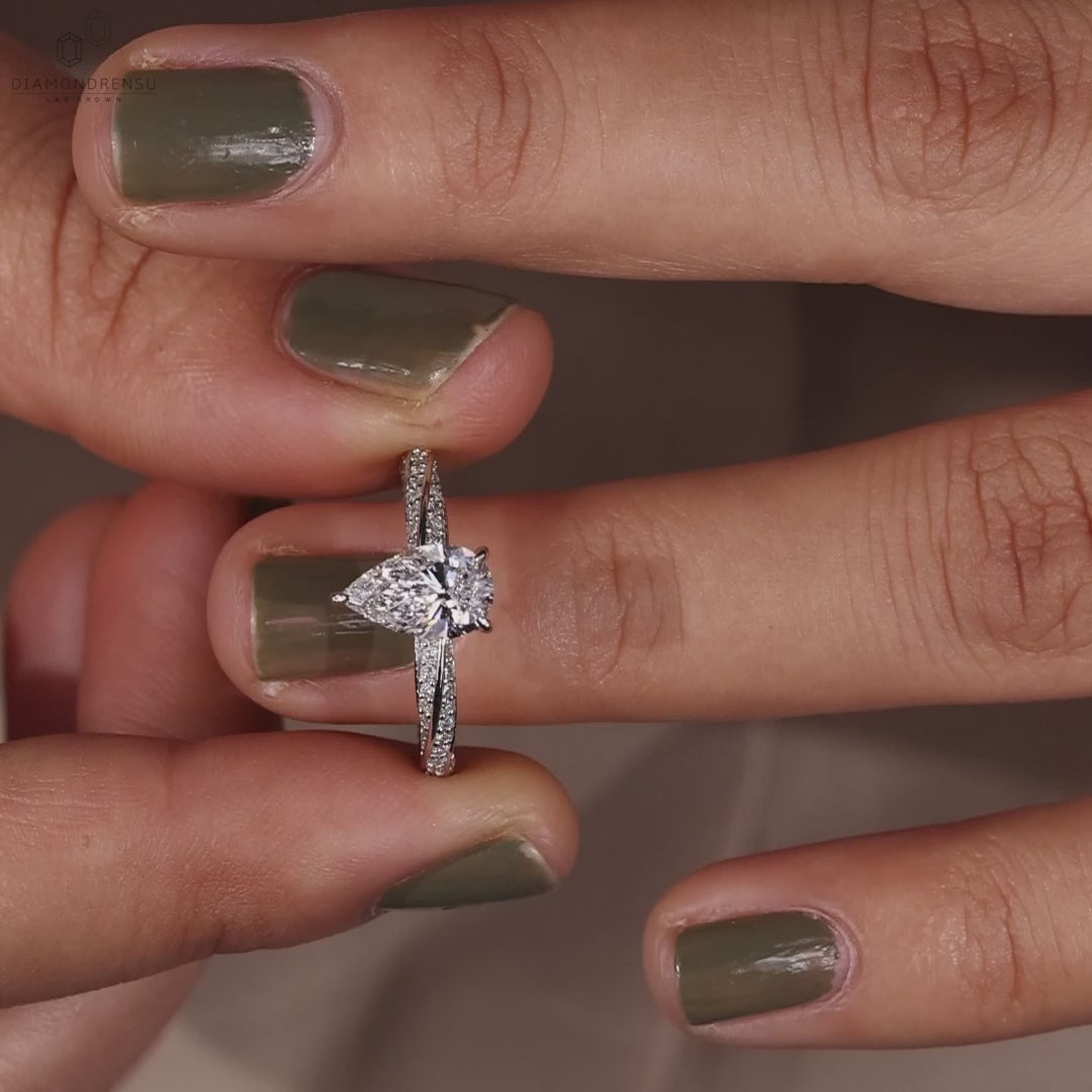 Model wearing a pear shaped diamond ring with a hidden halo design.