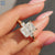 Radiant cut centre stone ring crafted in yellow gold with a hidden halo.
