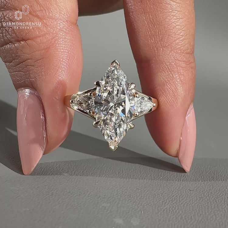 Marquise engagement ring featuring pear side stones.
