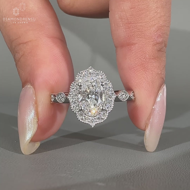 Milgrain ring featuring oval and round diamonds.
