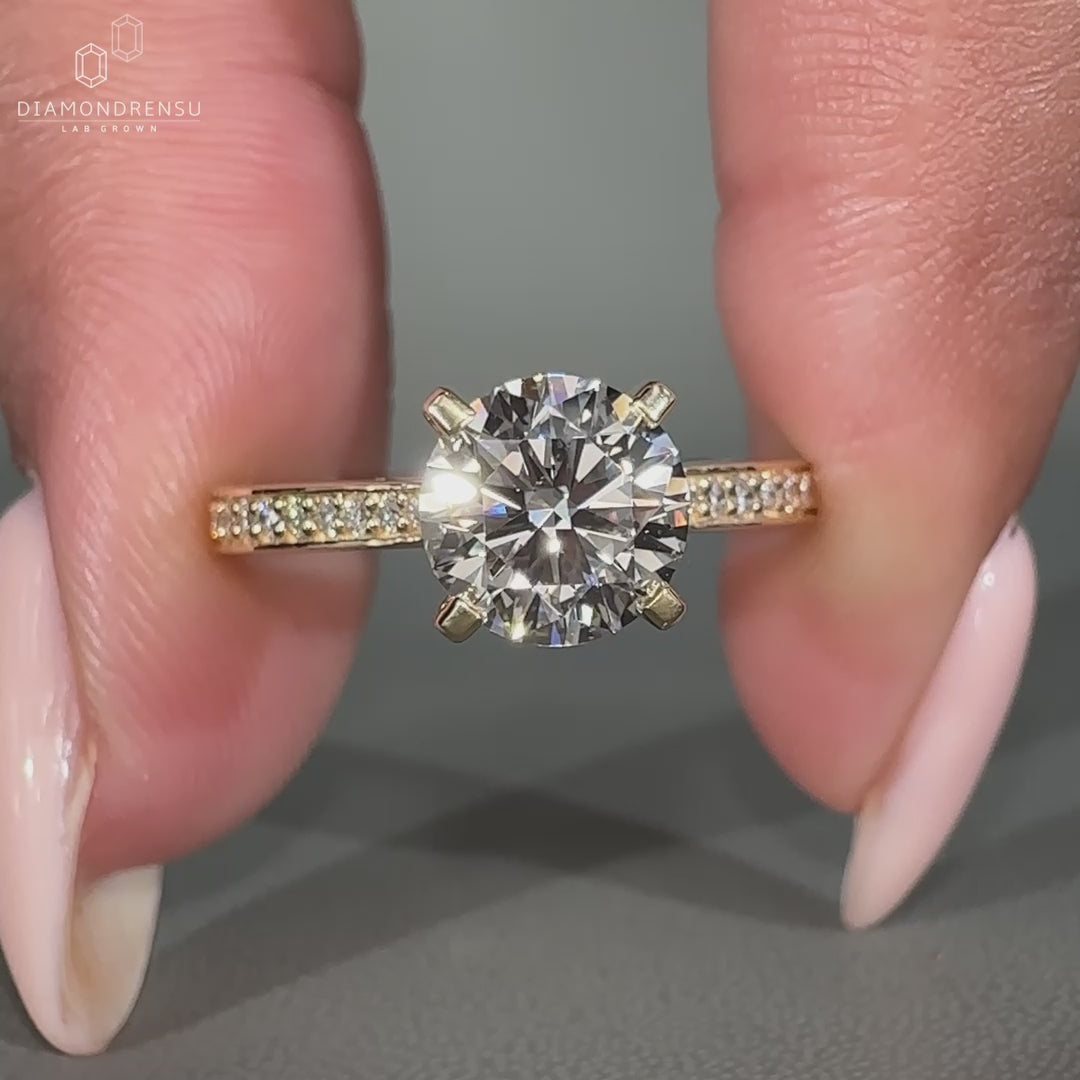Round cut diamond ring in yellow gold engagement ring style.
