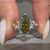Green centre diamond ring with round side stones.