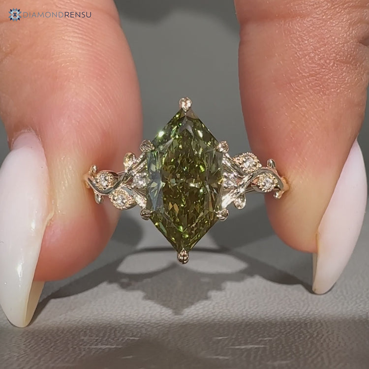 Green centre diamond ring with round side stones.