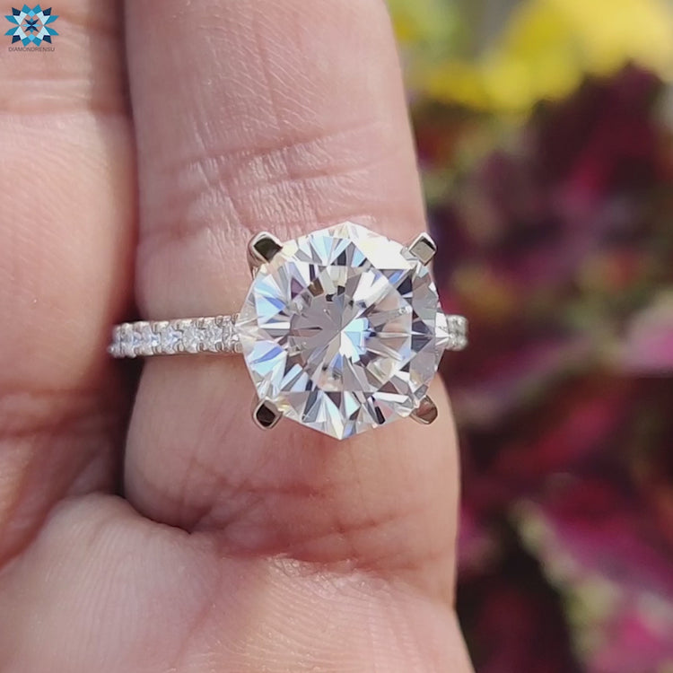 White gold engagement ring with round pave and center moissanite.
