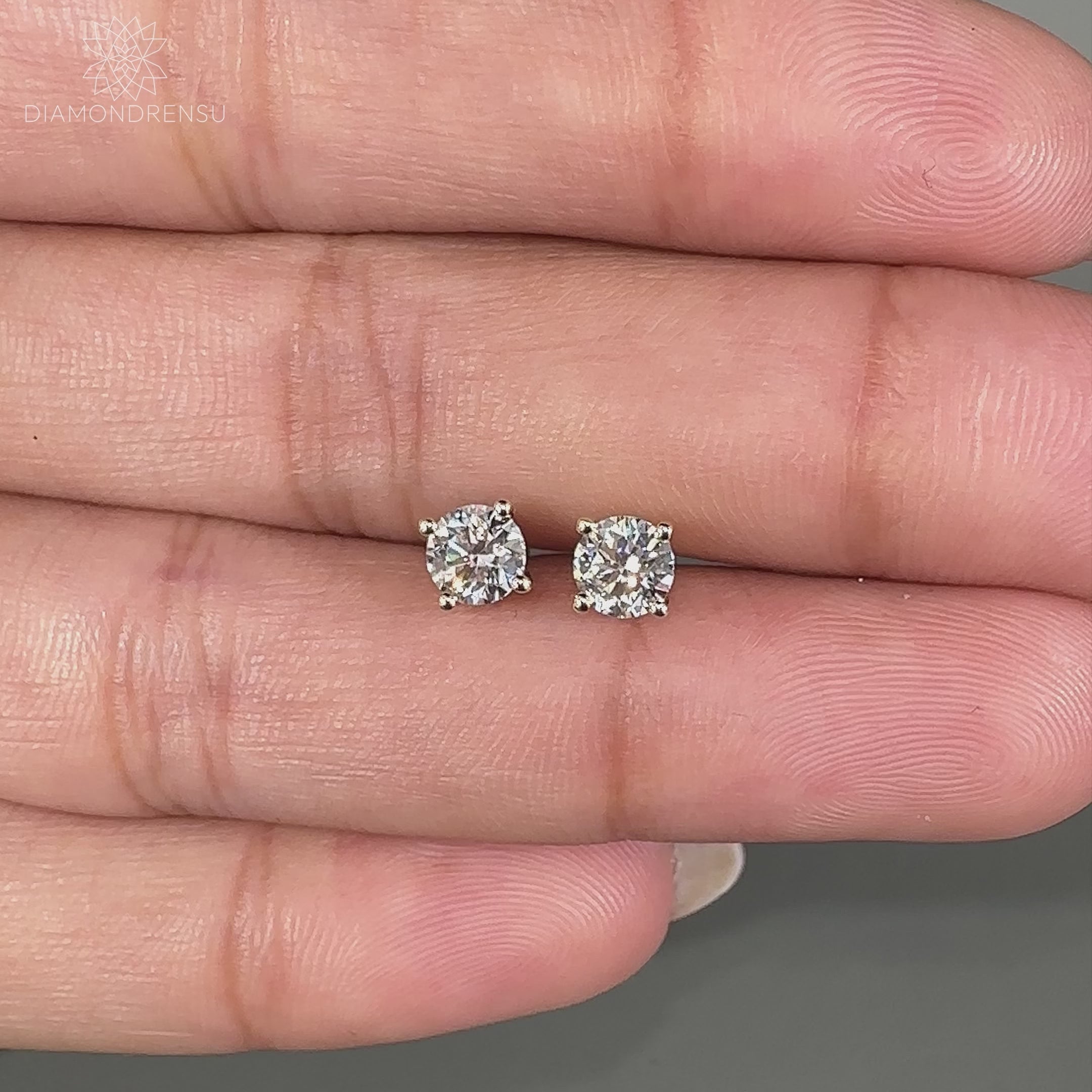 Handmade yellow gold earrings featuring lab grown round diamonds.
