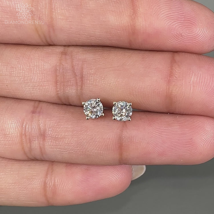 Handmade yellow gold earrings featuring lab grown round diamonds.
