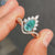 Twisted pave ring with cyan blue pear Moissanite in halo setting.
