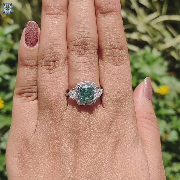 Double claw prong engagement ring in white gold with cyan moissanite.
