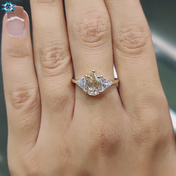 Pear shaped ring in a 3 Stone Engagement Ring with yellow gold.