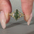 Green centre diamond ring with trillion side stones.