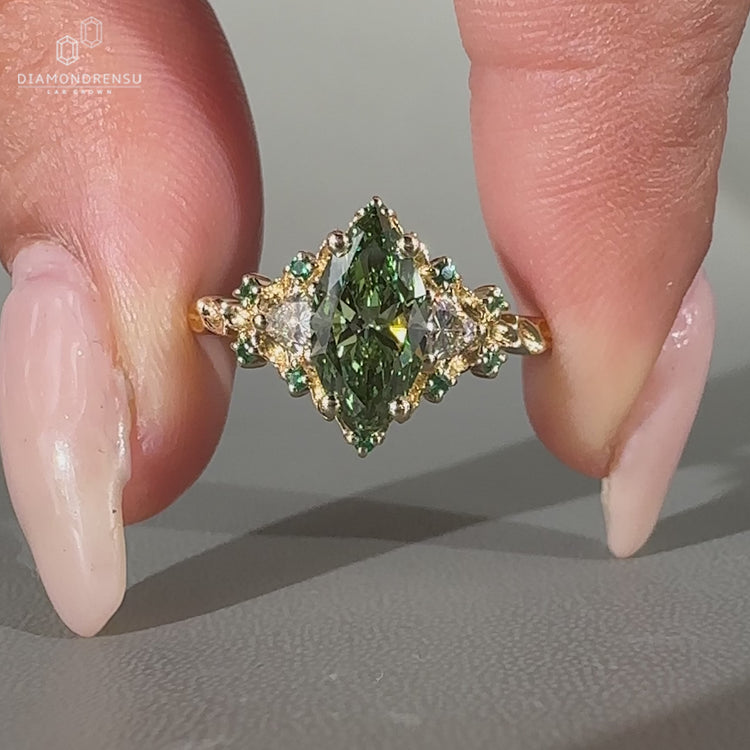 Green centre diamond ring with trillion side stones.