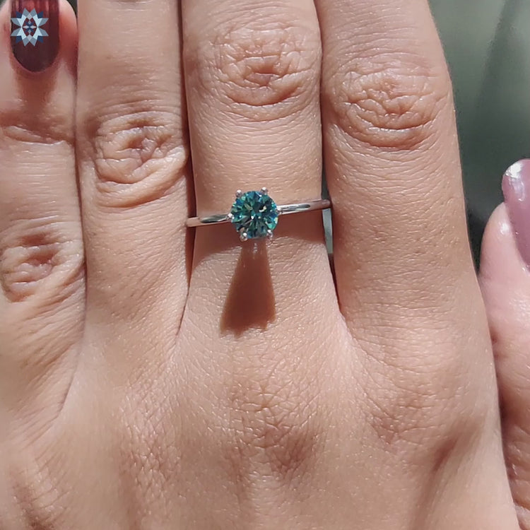 Blue round cut moissanite ring in a simple solitaire style.
