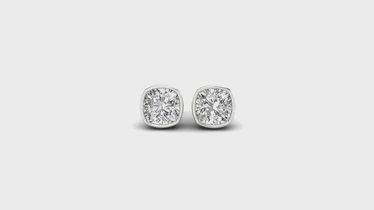 White gold bezel set earrings with cushion cut diamonds.
