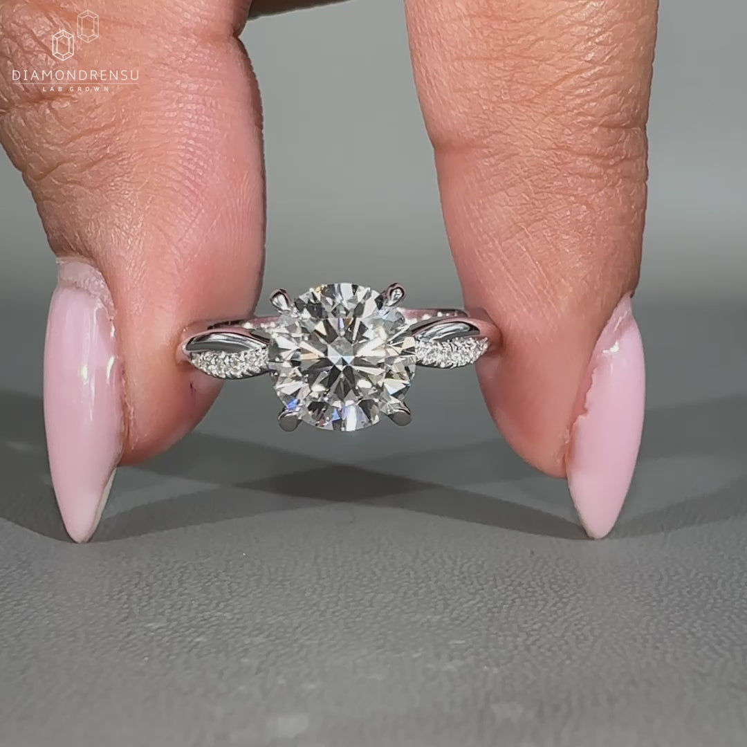 Round cut diamond ring featuring twisted pave design and claw prong setting.
