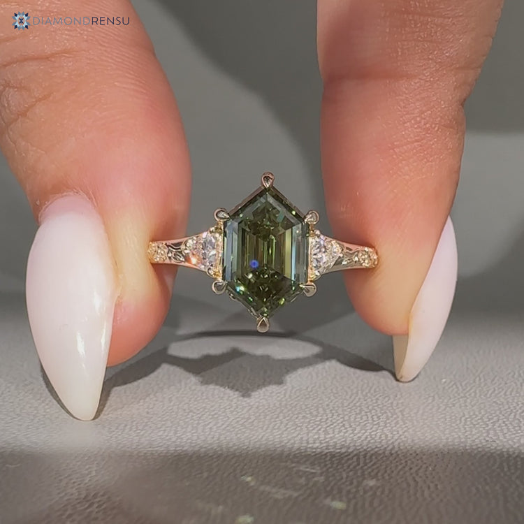 Green hexagon diamond ring with trillion side stones.