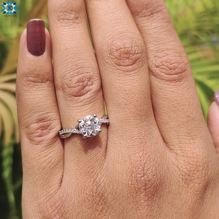 Moissanite ring with twisted pave band in white gold.
