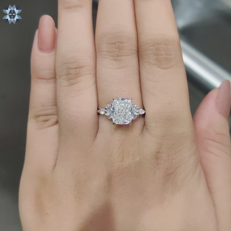 Handmade moissanite ring with cushion and round cuts in prong setting.
