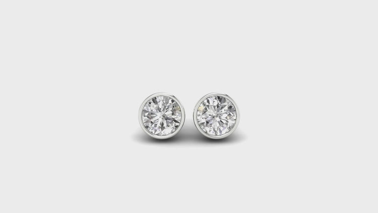 Lab grown diamond bezel earrings in classic round cut, white gold finish.
