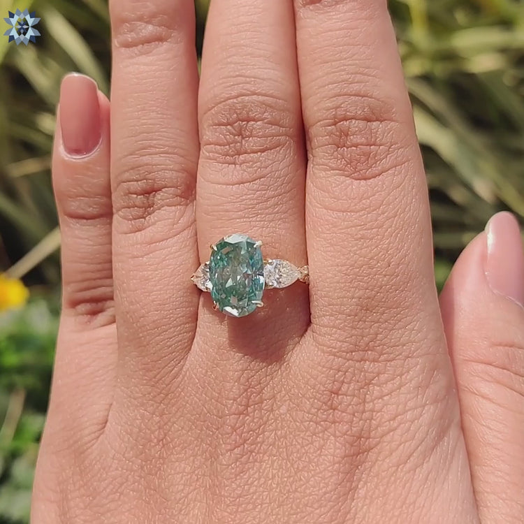 Handmade moissanite ring with pear side stones and a twisted pave band.
