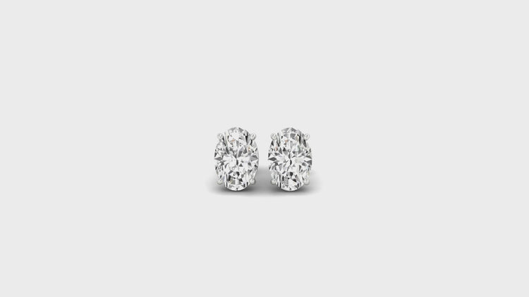 Oval cut diamond gold stud earrings in classic basket setting.
