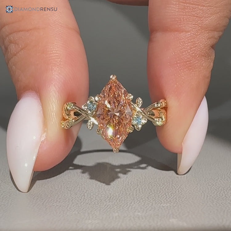 Marquise diamond ring with blue round side stones.