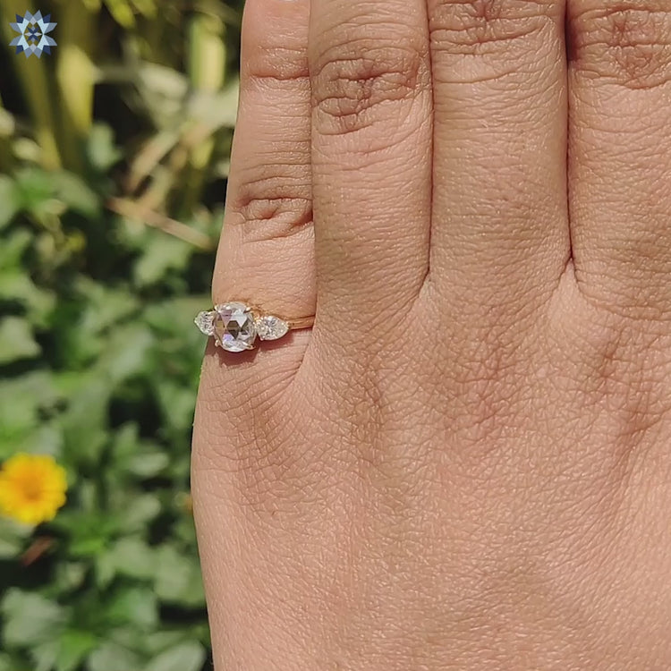 Handcrafted yellow gold ring with round and pear stones.
