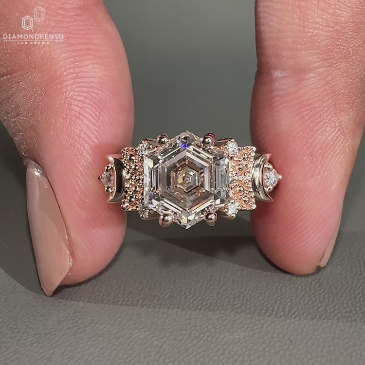Hexagon engagement ring set with round diamond side stone.
