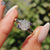 Portuguese cut moissanite ring crafted in white gold with a bypass setting.
