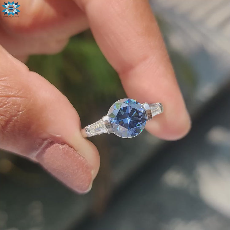 Dark blue three stone moissanite ring in white gold setting.
