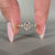 Five stone ring featuring emerald cut center diamond.
