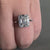 Round diamond engagement ring in a unique side stone design, perfect for women who love classic elegance.