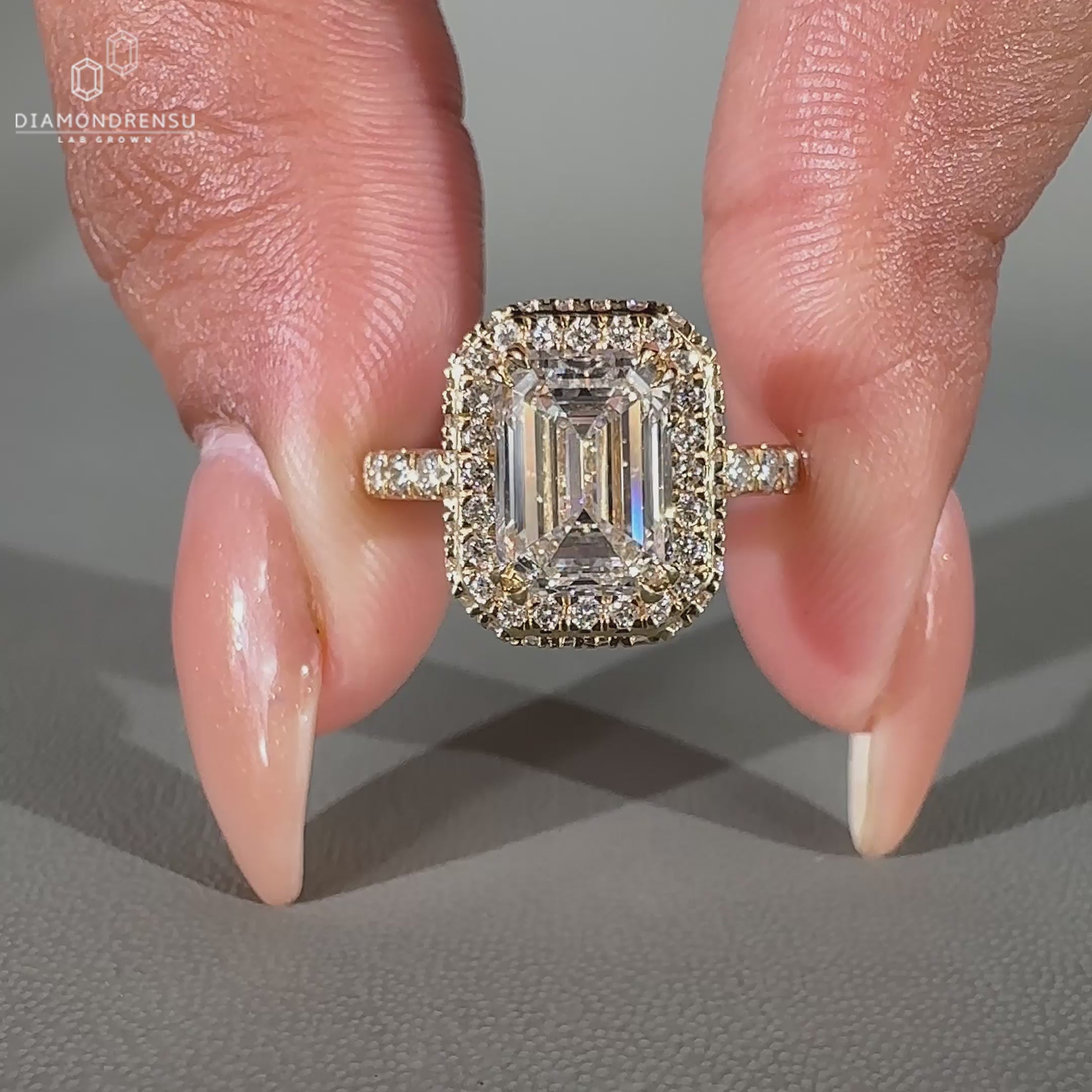 This emerald engagement ring features a two side halo ring and pave setting ring.
