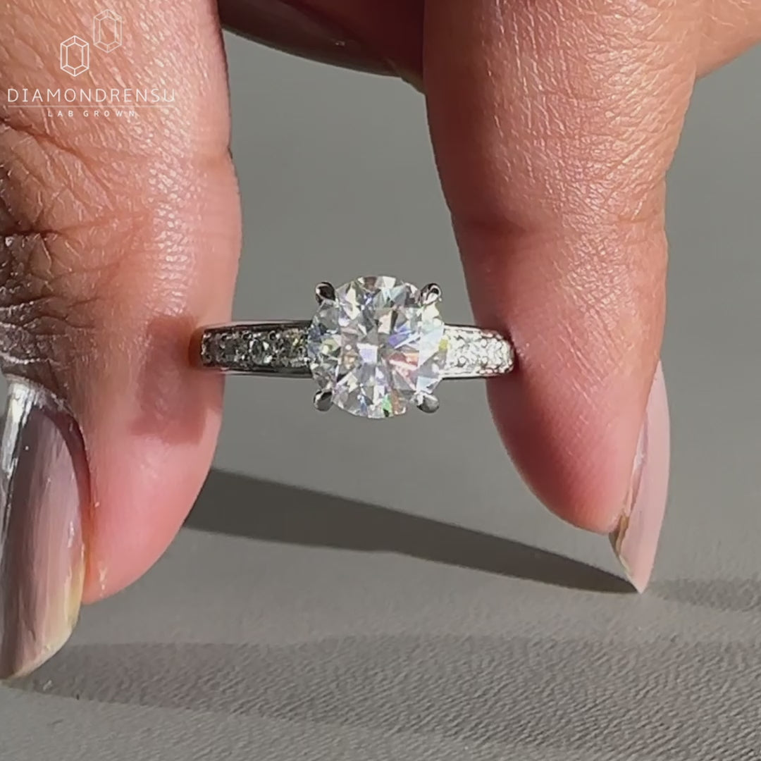 Round diamond ring designed with tapered pave set.
