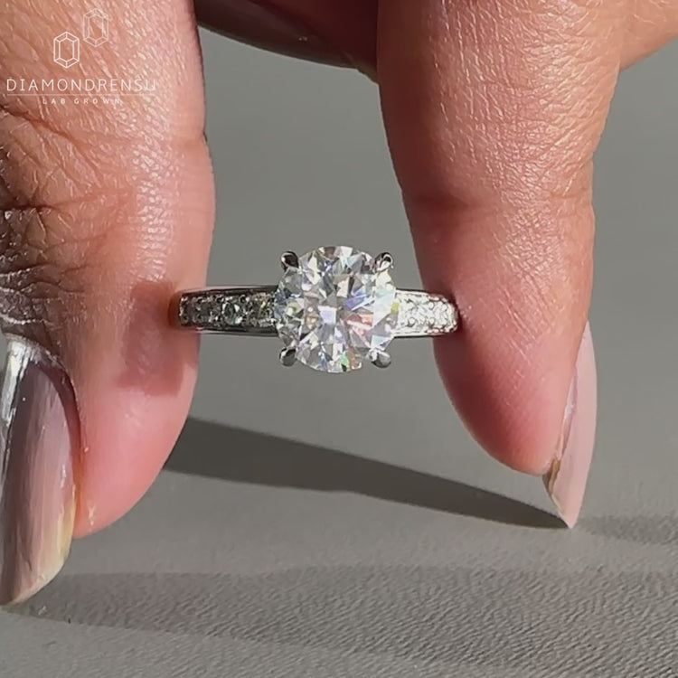 Round diamond ring designed with tapered pave set.
