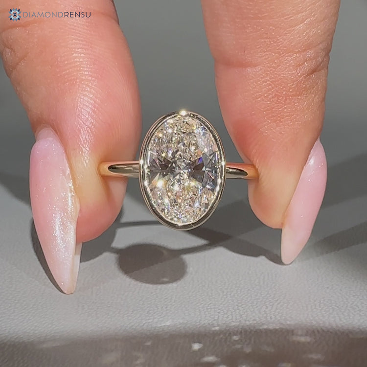 Handmade oval solitaire ring with a bezel setting.