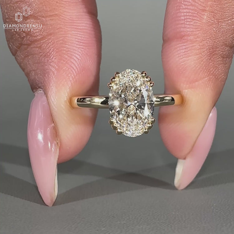 Solitaire oval diamond ring with hidden round accent stones.