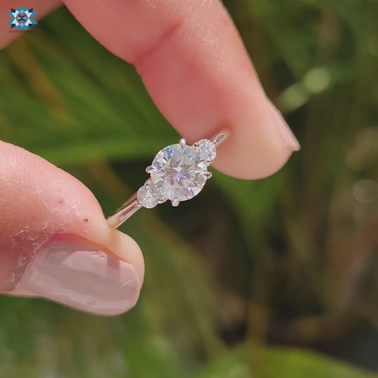 Round cut moissanite centre with two round side stones, white gold.
