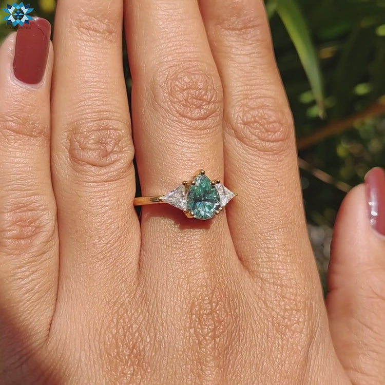 Yellow gold moissanite ring with pear and triangle cuts.
