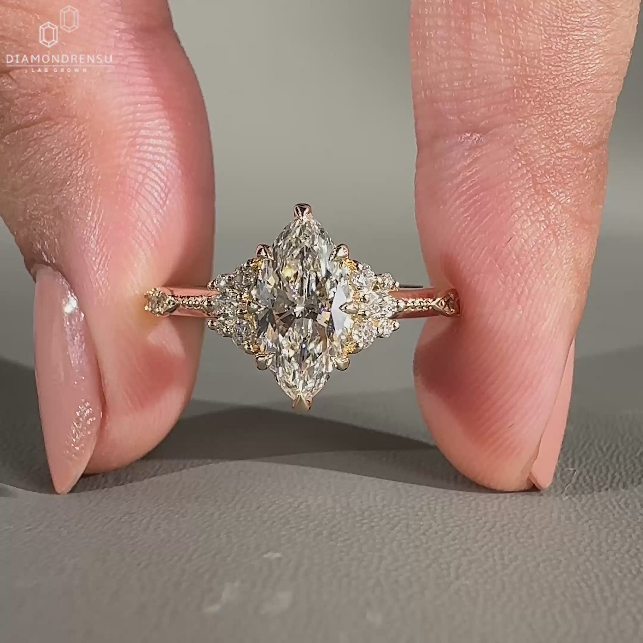 Marquise cut diamond cluster ring with round side diamonds.
