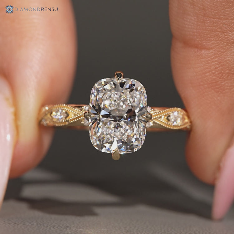 Cushion cut ring with marquise side stones and milgrain details.