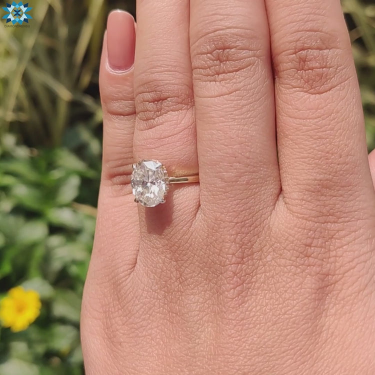 Oval moissanite engagement ring with hidden halo and four claw prongs.
