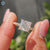 Princess cut Moissanite engagement ring with 4 claw prong and elegant pave band.

