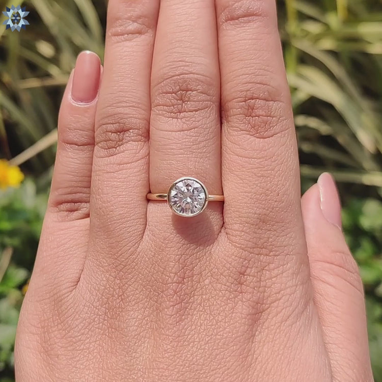 Yellow gold solitaire with round cut moissanite centerpiece.
