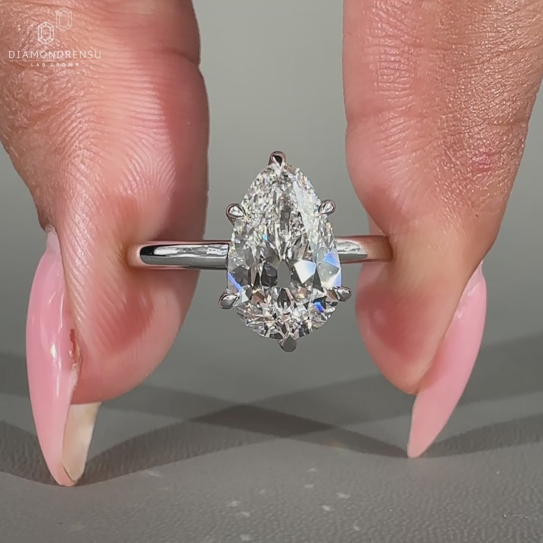 Pear shaped diamond ring featuring 6 prong claw setting and custom design.