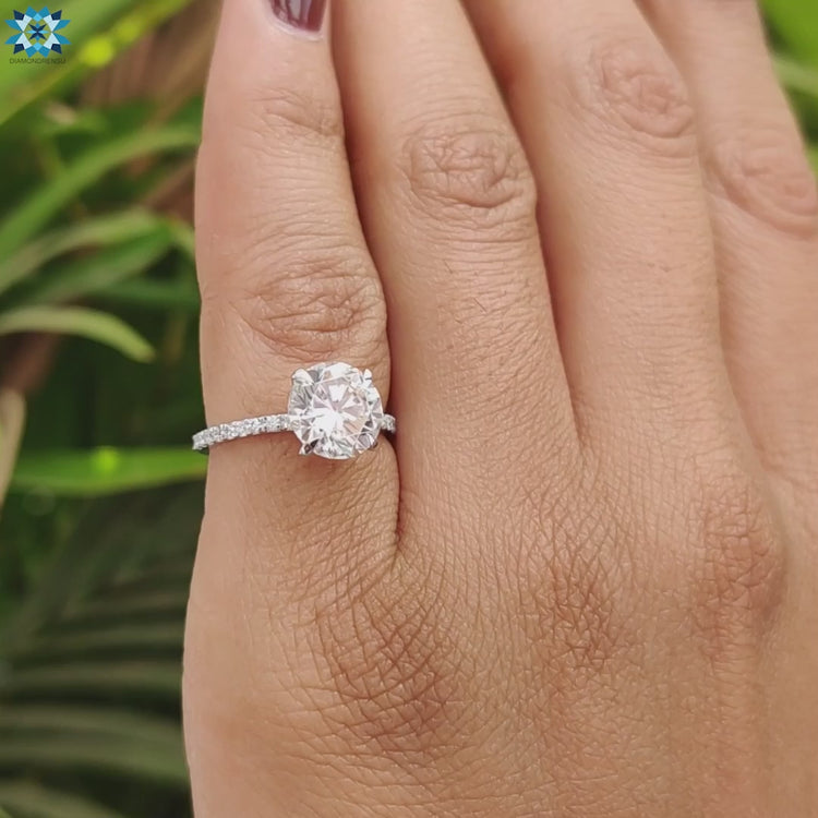 White gold engagement ring with round moissanite center.
